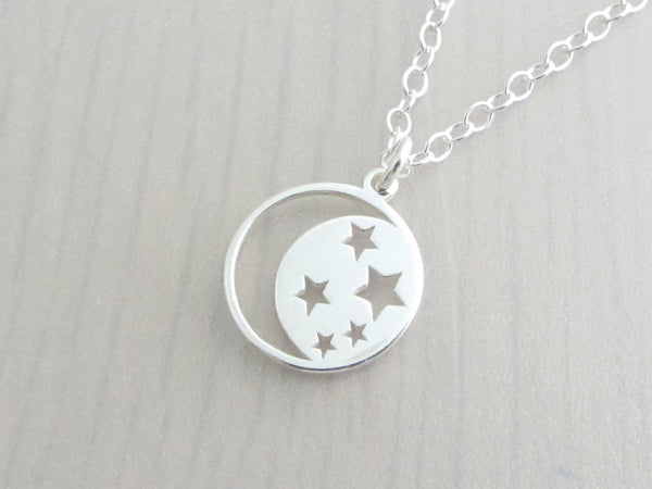 silver crescent moon with cut out stars charm on a silver chain
