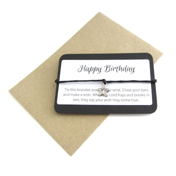 stainless steel hollow star charm on black cord string attached to a message card stating 'happy birthday' and note to make a wish when tying the bracelet around a wrist with a brown craft paper envelope