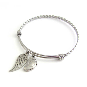 stainless steel single angel wing charm and a single foot charm with indented heart on a bangle with braided twist pattern