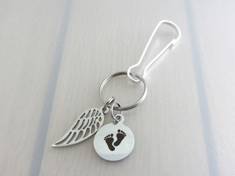 stainless steel single angel wing charm and a laser engraved baby footprints charm on a bag charm with snap clip hook