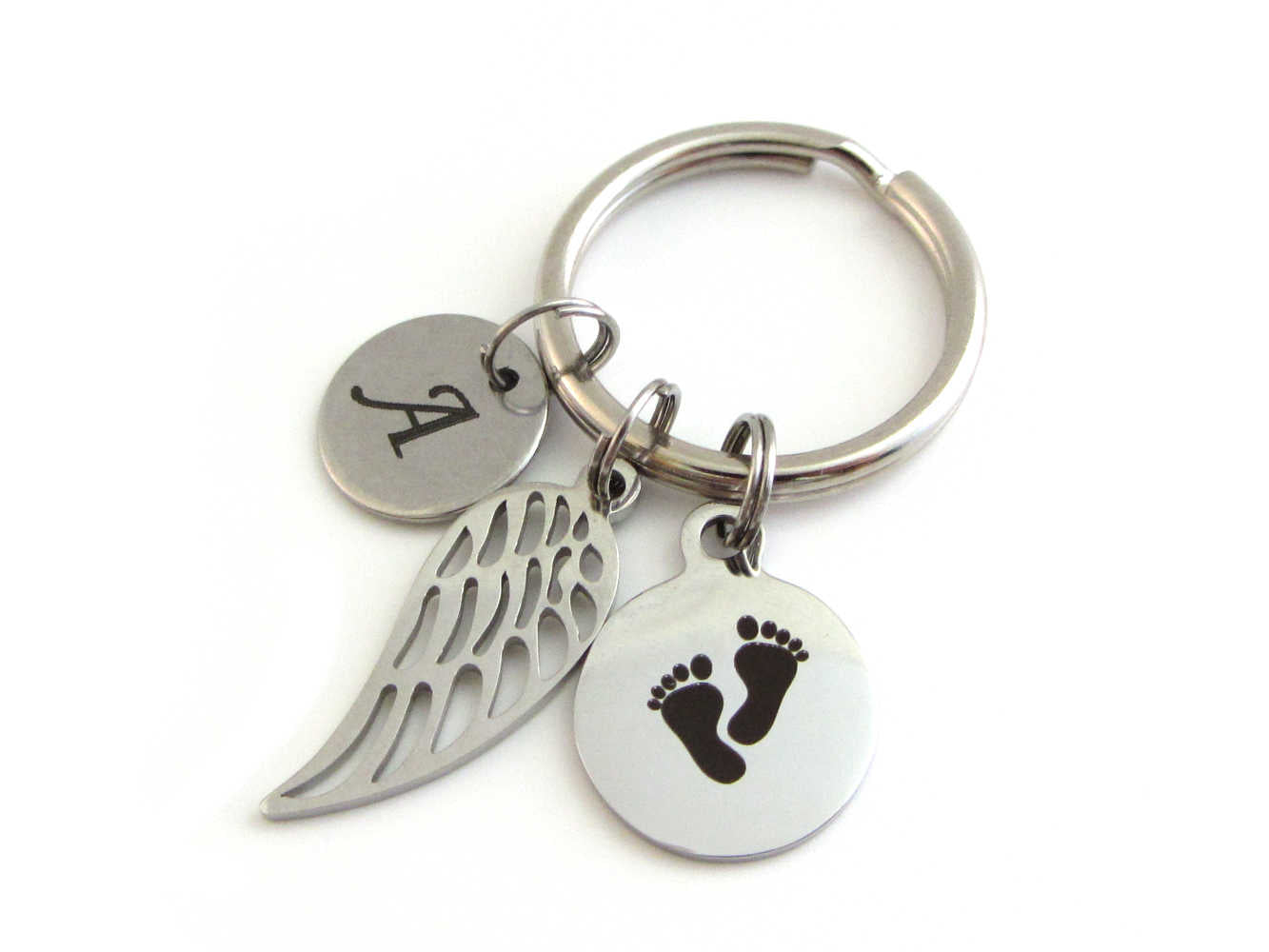 stainless steel laser engraved capital initial letter disc charm, a single angel wing and a laser engraved baby footprints charm on a keyring