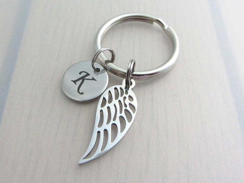 stainless steel laser engraved capital initial letter disc charm and single angel wing on a keyring
