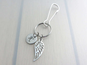 stainless steel laser engraved capital initial letter disc charm and single angel wing charm on a bag charm with snap clip hook
