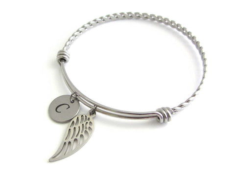 stainless steel laser engraved capital initial letter disc charm and single angel wing charm on a bangle with braided twist pattern