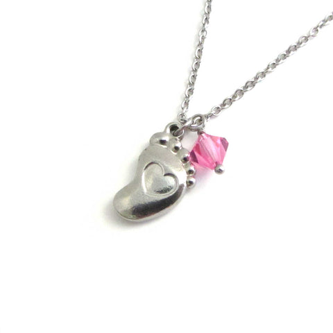 a single foot charm with indented heart with pink crystal on a stainless steel chain