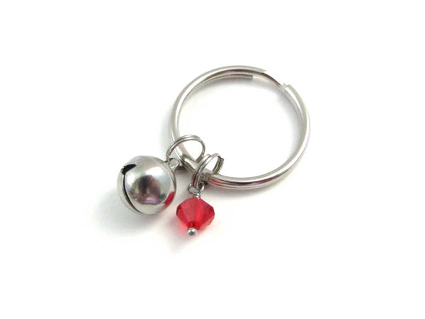 stainless steel bell charm and a red crystal charm on a keyring