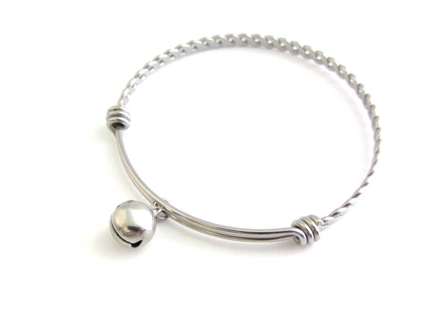 stainless steel bell charm on a bangle with braided twist pattern