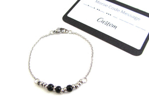'sarah' name bracelet written in morse code with stainless steel and black glass seed beads on a stainless steel chain with custom morse code message card