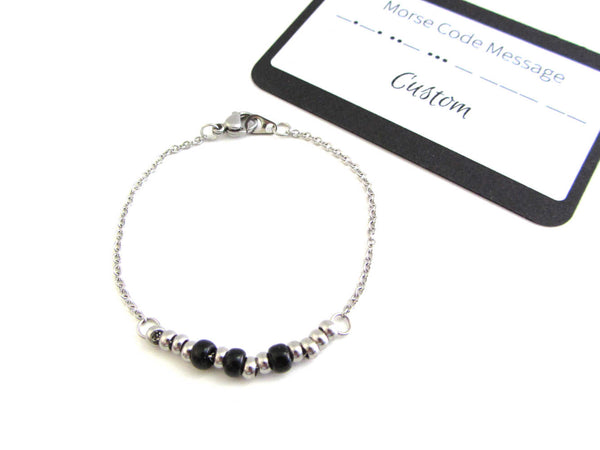 'sarah' name bracelet written in morse code with stainless steel and black glass seed beads on a stainless steel chain with custom morse code message card