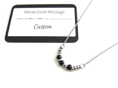 'sarah' name necklace written in morse code with fixed stainless steel and black glass seed beads on a stainless steel chain with custom morse code message card