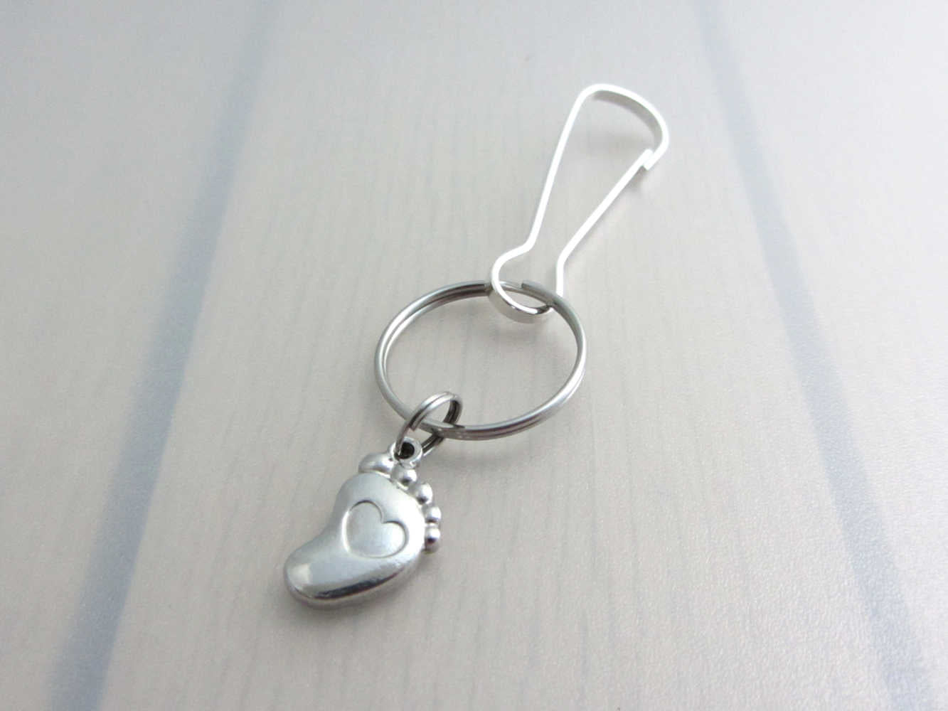stainless steel single foot charm with indented heart on a bag charm with snap clip hook