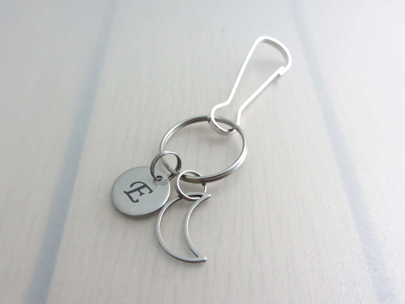 stainless steel laser engraved capital initial letter disc charm and hollow crescent moon charm on a bag charm with snap clip hook
