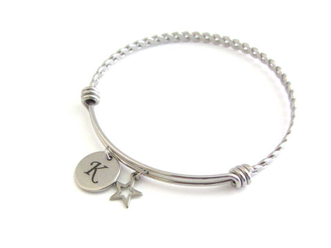 stainless steel laser engraved capital initial letter disc charm and hollow star charm on a bangle with braided twist pattern