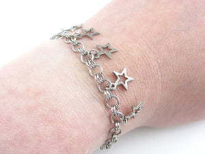 five small hollow star charms on a handmade chainmaille stainless steel chain bracelet on wrist