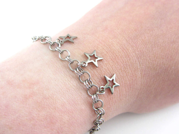 three small hollow star charms on a handmade chainmaille stainless steel chain bracelet on wrist