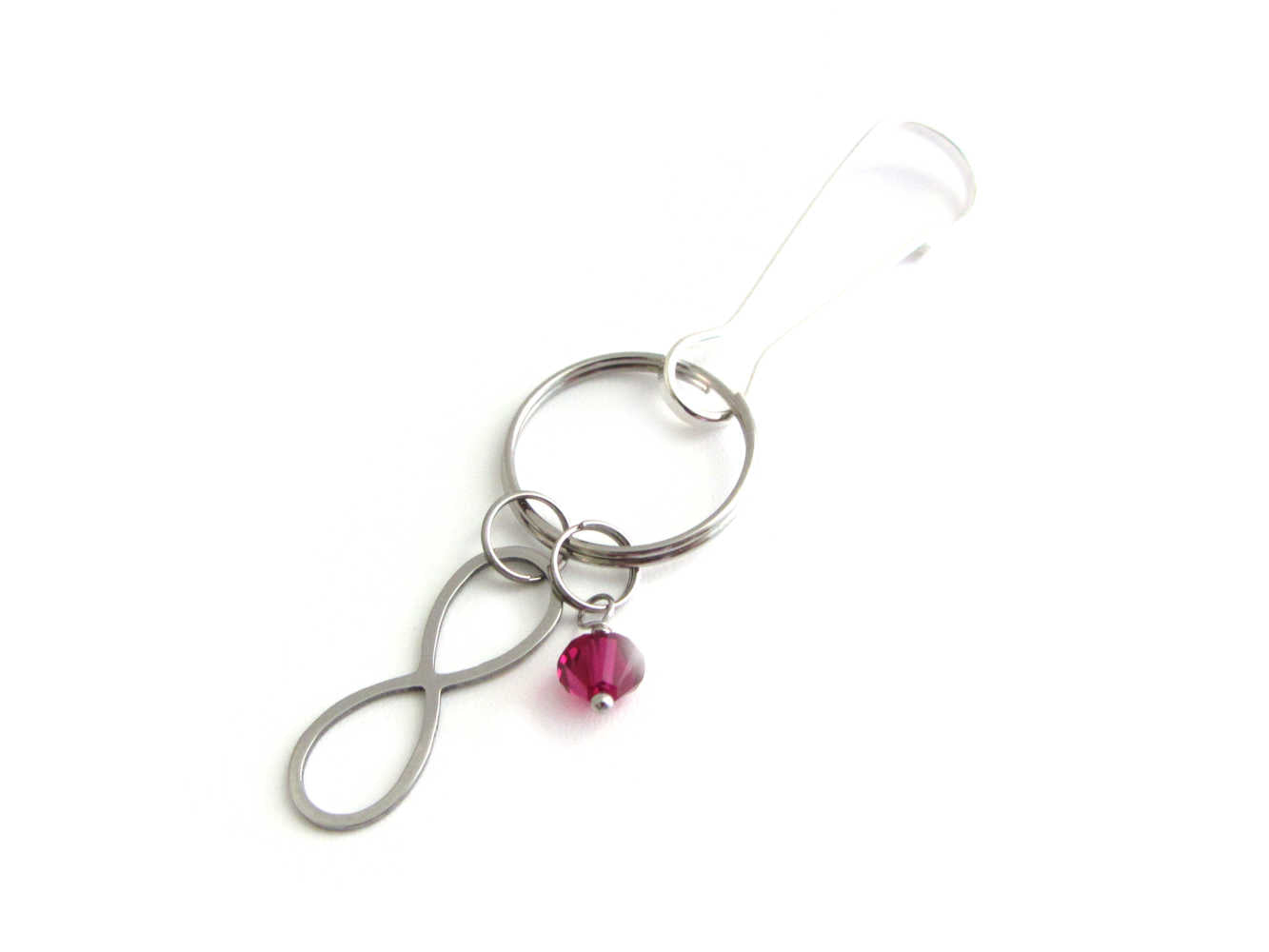 stainless steel infinity charm and a red crystal charm on a bag charm with snap clip hook