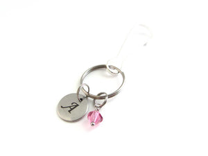 stainless steel laser engraved capital initial letter disc charm and a pink crystal charm on a bag charm with snap clip hook