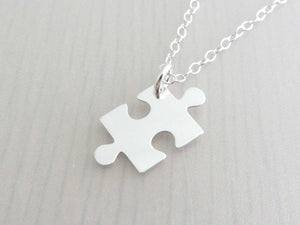 silver jigsaw puzzle piece charm on a silver chain