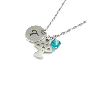 laser engraved capital initial letter disc charm, mushroom toadstool charm and a blue/green crystal charm on a stainless steel chain