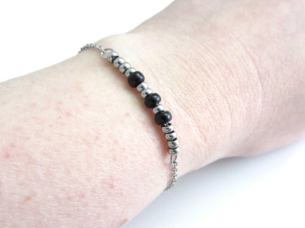 'sarah' stainless steel and black glass sead beads morse code bracelet worn on wrist for others to read