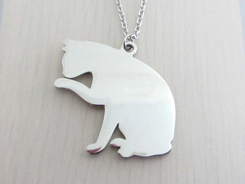 pet cat sitting licking paw charm on a stainless steel chain