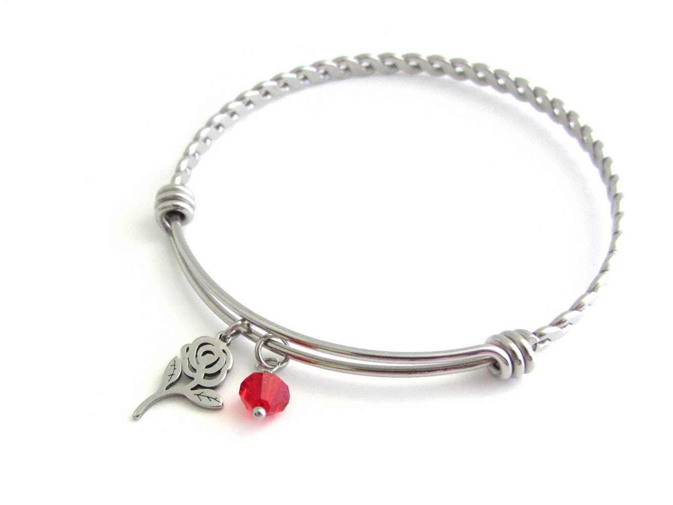 rose flower charm and a red crystal charm on a bangle with braided twist pattern
