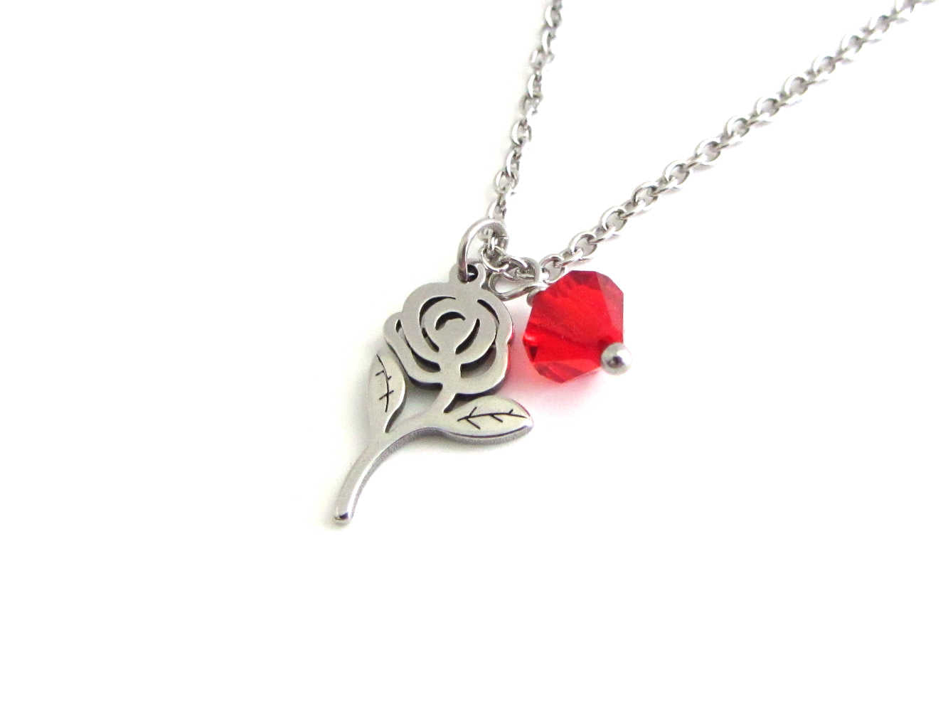 rose flower charm and a red crystal charm on a stainless steel chain