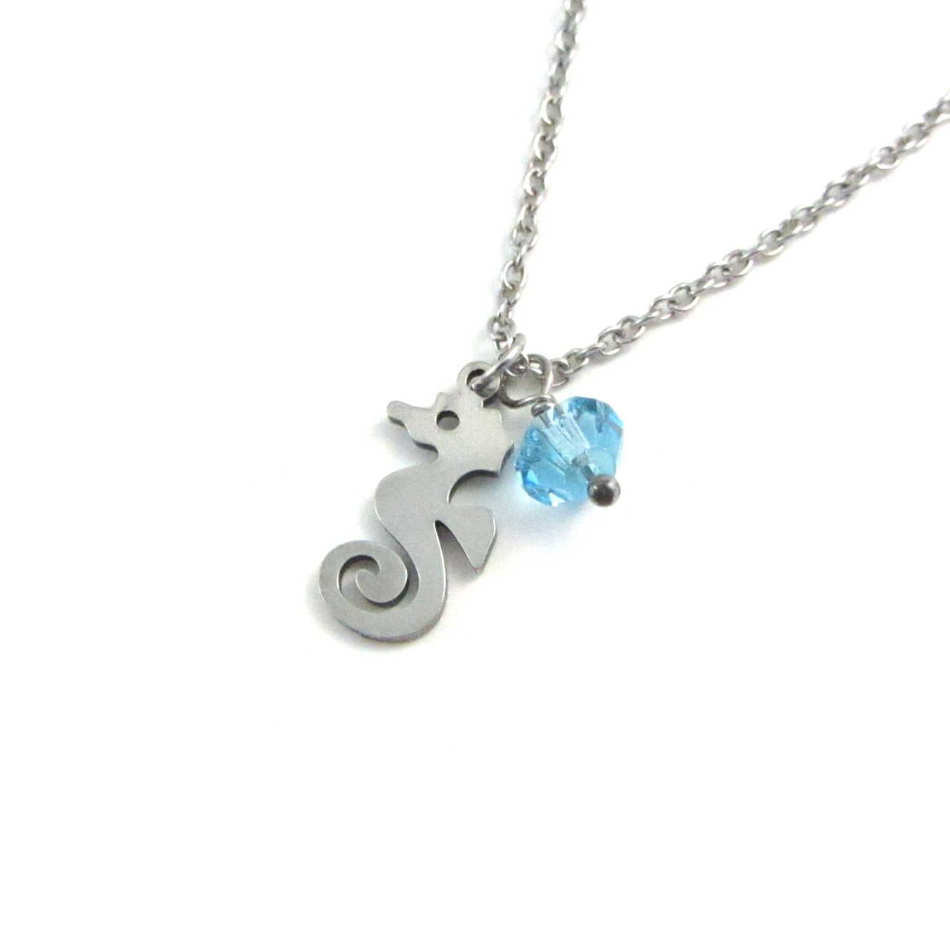 nautical seahorse charm and a light blue crystal charm on a stainless steel chain