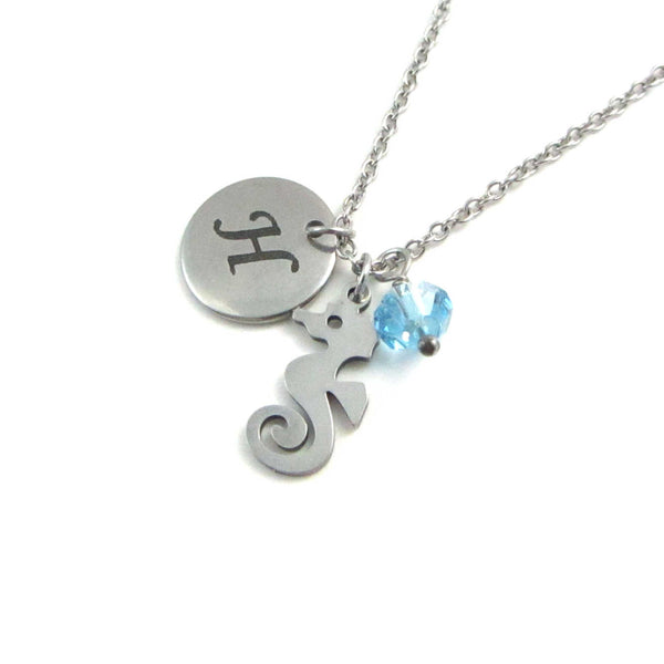 laser engraved capital initial letter disc charm, nautical seahorse charm and a light blue crystal charm on a stainless steel chain