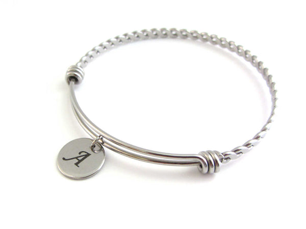 stainless steel laser engraved capital initial letter disc charm on a bangle with braided twist pattern
