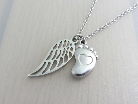 single angel wing charm and a single foot charm with indented heart on a stainless steel chain