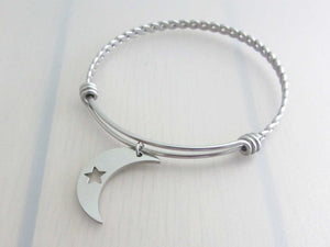 stainless steel crescent moon charm with cut out star on a bangle with braided twist pattern