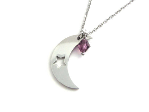 A crescent moon charm with cut out star and a purple crystal charm on a stainless steel chain