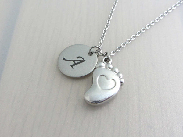laser engraved capital initial letter disc charm and a single foot charm with indented heart on a stainless steel chain