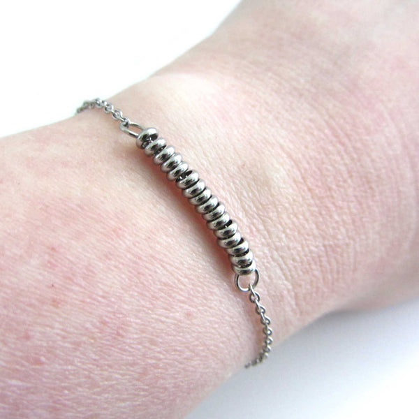 16 stainless steel bead one for each year bracelet on a stainless steel chain shown worn on wrist