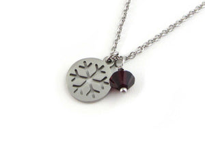 snowflake charm and a red crystal charm on a stainless steel chain
