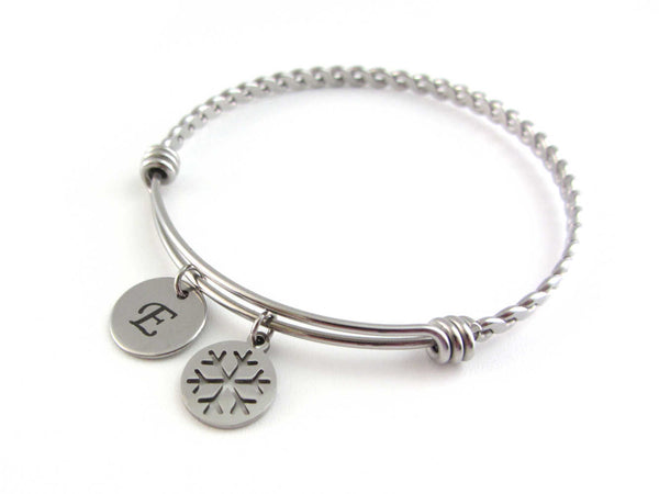stainless steel laser engraved capital initial letter disc charm and snowflake charm on a bangle with braided twist pattern
