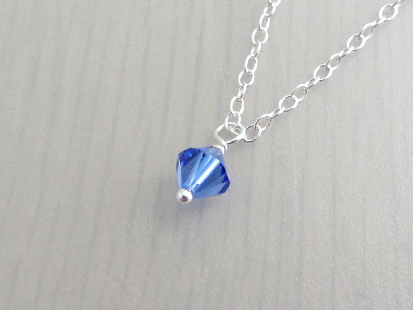 blue coloured crystal charm on a silver chain