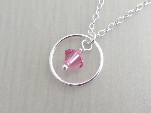 silver circle ring and pink coloured crystal charm on a silver chain