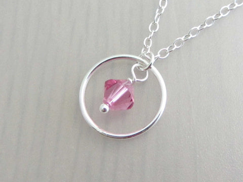 silver circle ring and pink coloured crystal charm on a silver chain