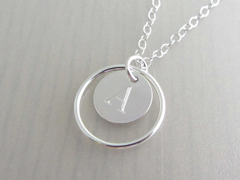 silver circle ring and engraved capital initial letter disc charm on a silver chain