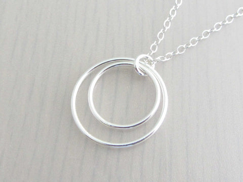 two silver circle rings on a silver chain