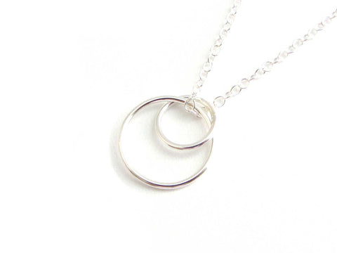two linked silver circle ring pendant hanging on a silver chain