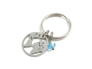 stainless steel world earth map charm and a light blue crystal charm on a keyring