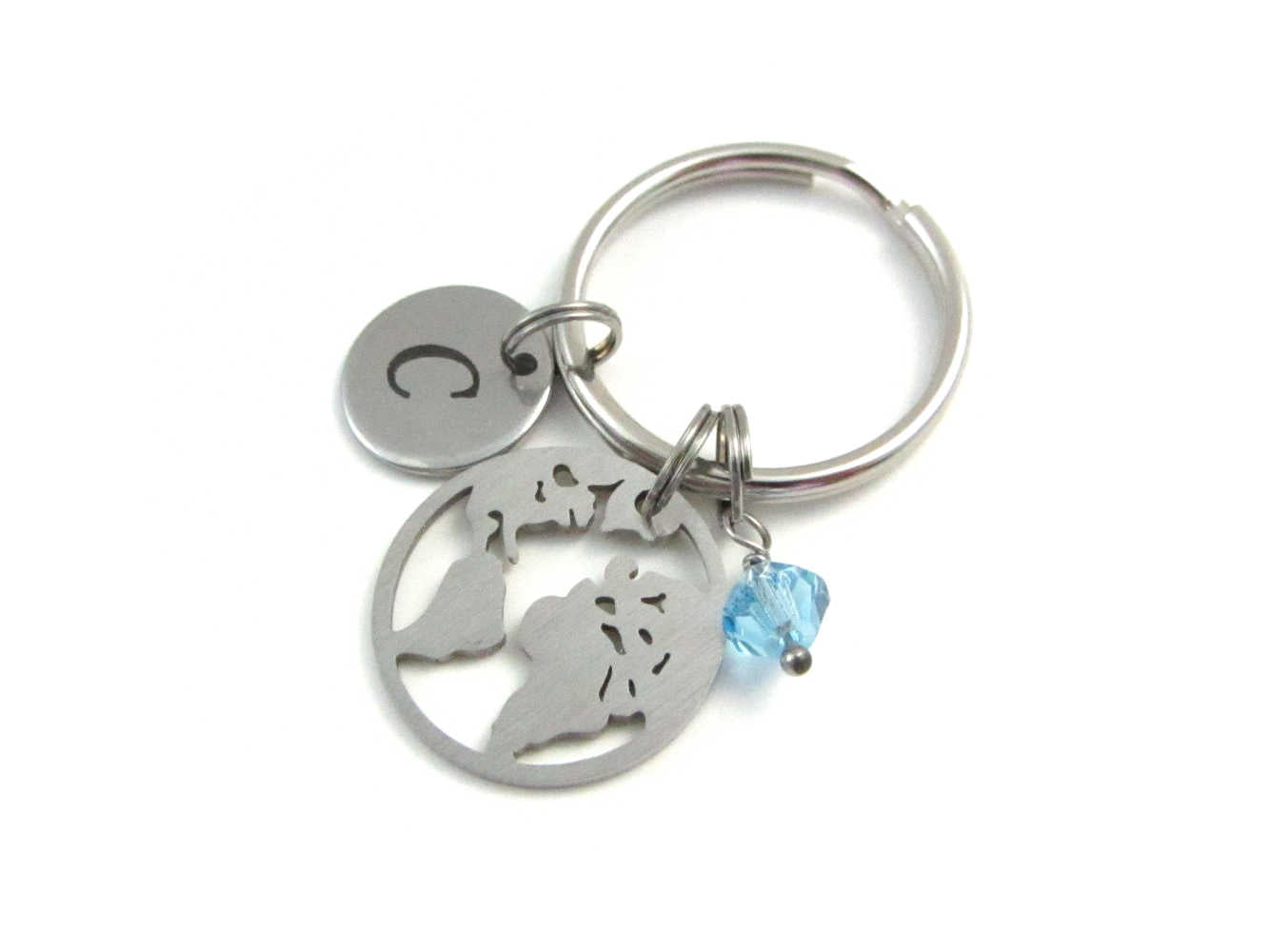 laser engraved capital initial letter disc charm, stainless steel world earth map charm and a light blue crystal charm on a keyring